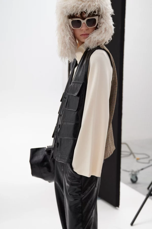 Zwart eco-leren damesgilet met V-hals, klepzakken en pied-de-poule achterzijde, model draagt one size, merk Lumina.