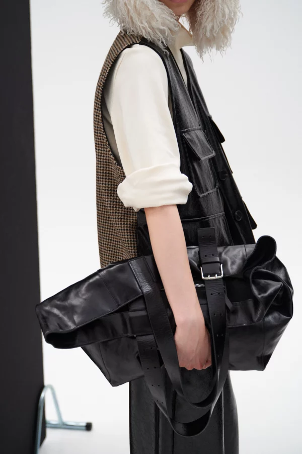 Zwart eco-leren damesgilet met V-hals, klepzakken en pied-de-poule achterzijde, model draagt one size, merk Lumina.